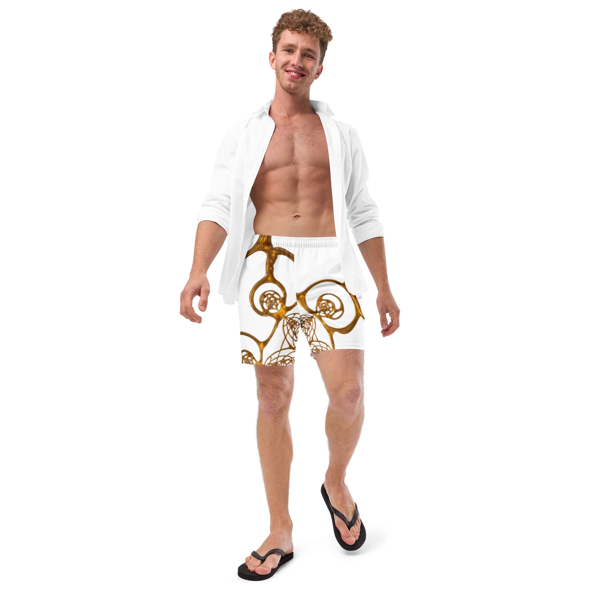 Man wearing Golden Cymatics Sacred Geometry Recycled Swim Trunks in white and gold pattern on beach